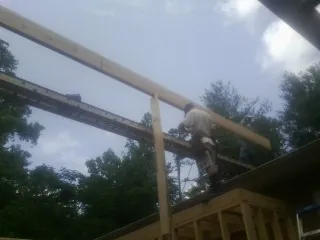 Carpenter setting a ridge beam over a new addition frame — Ice Dam Removal by Roofing Brothers in Avery