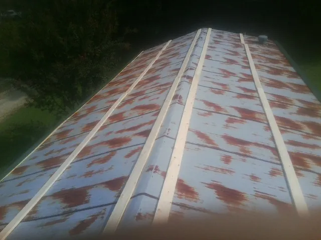 Rusted metal roof panels with new wood purlins before replacement — Storm Damage Roof Repair in Avery by Roofing Brothers