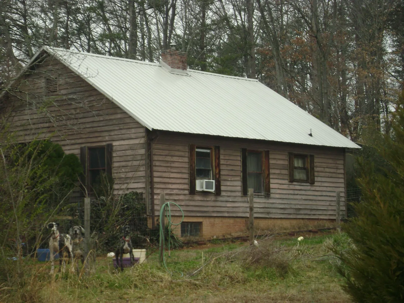 White metal roof on an old wood sided farmhouse, from a Metal Roof Installation job in Avery